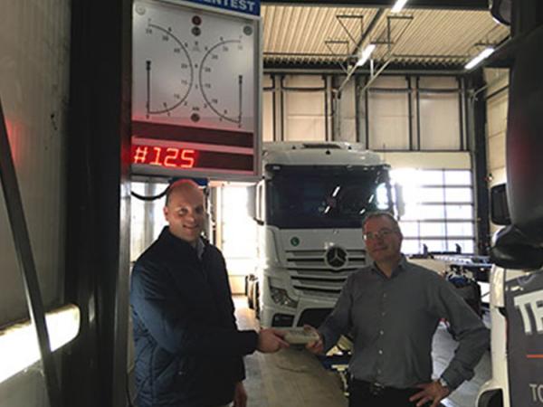Fotobijschrift: (links) Michiel van der Eijk (VLT) overhandigt Ernst Jansen (Truck Support Venlo) de bediening van de nieuwe, en daarmee de 125ste actieve VLT liftbank.